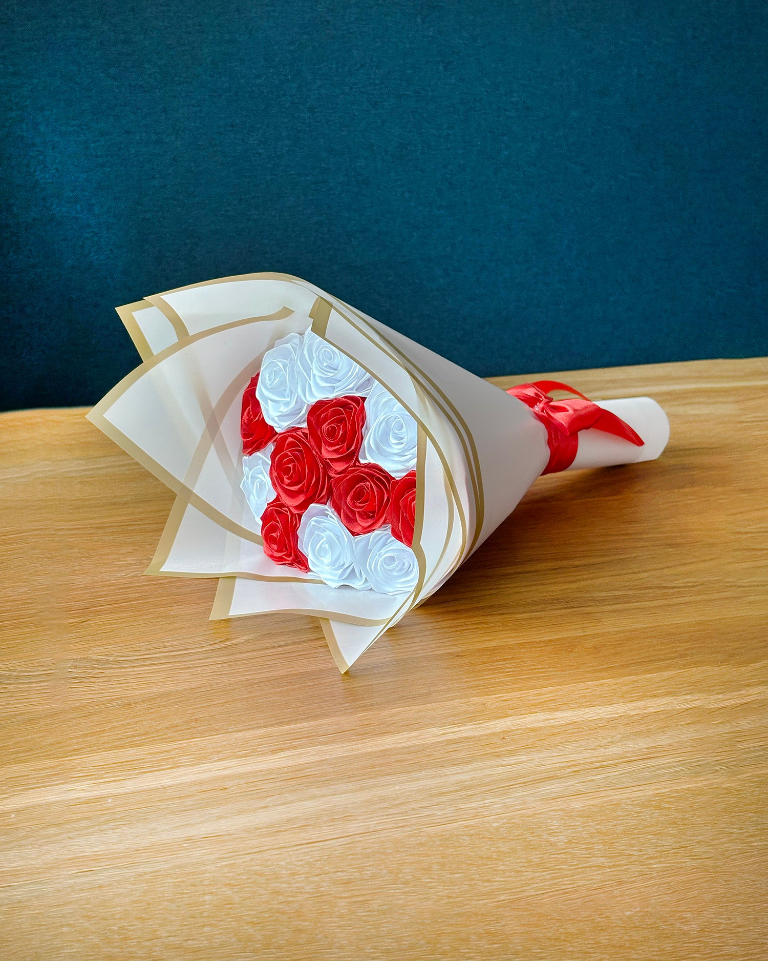 Rdece bel satenast sopek, dvanjastih vrtnic, ovit v roza korejski papir, rdeca pentlja.