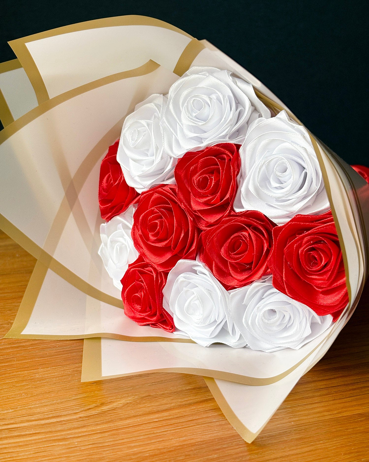 Satenast sopek v beli barvi in rdeci barvi, zavit v bel papir, zlata obroba