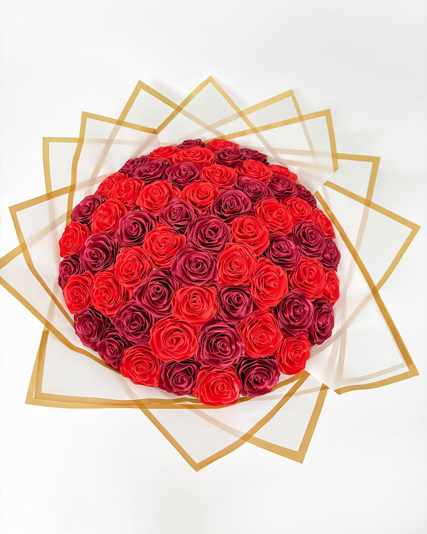 Ročno izdelane satenaste vrtnice v bordo rdeči in rdeči barvi. Zavite v bel korejski papir z zlato obrobo. 