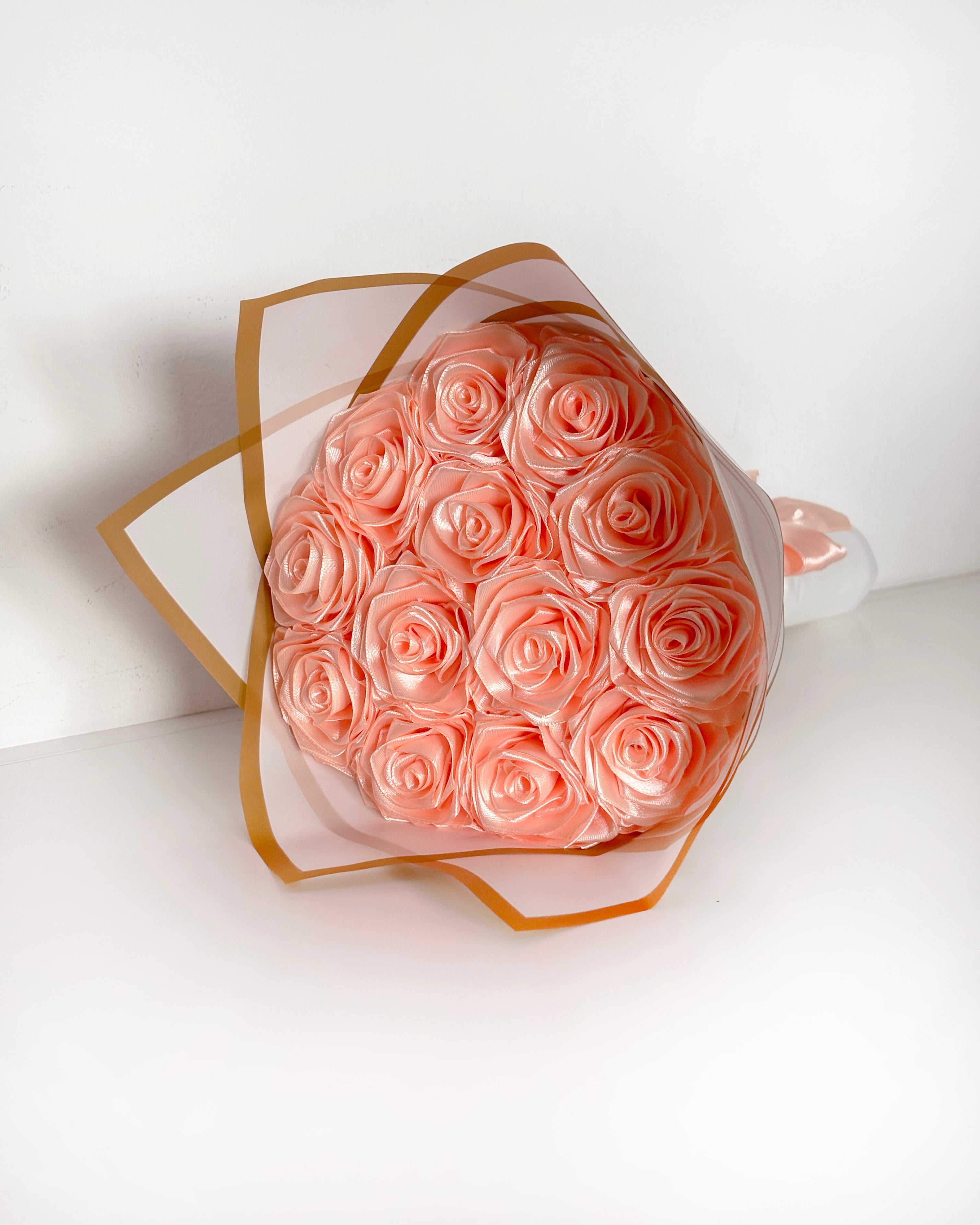 Satenast šopek vrtnic, v marelični barvi, zavit v bel korejski papir
