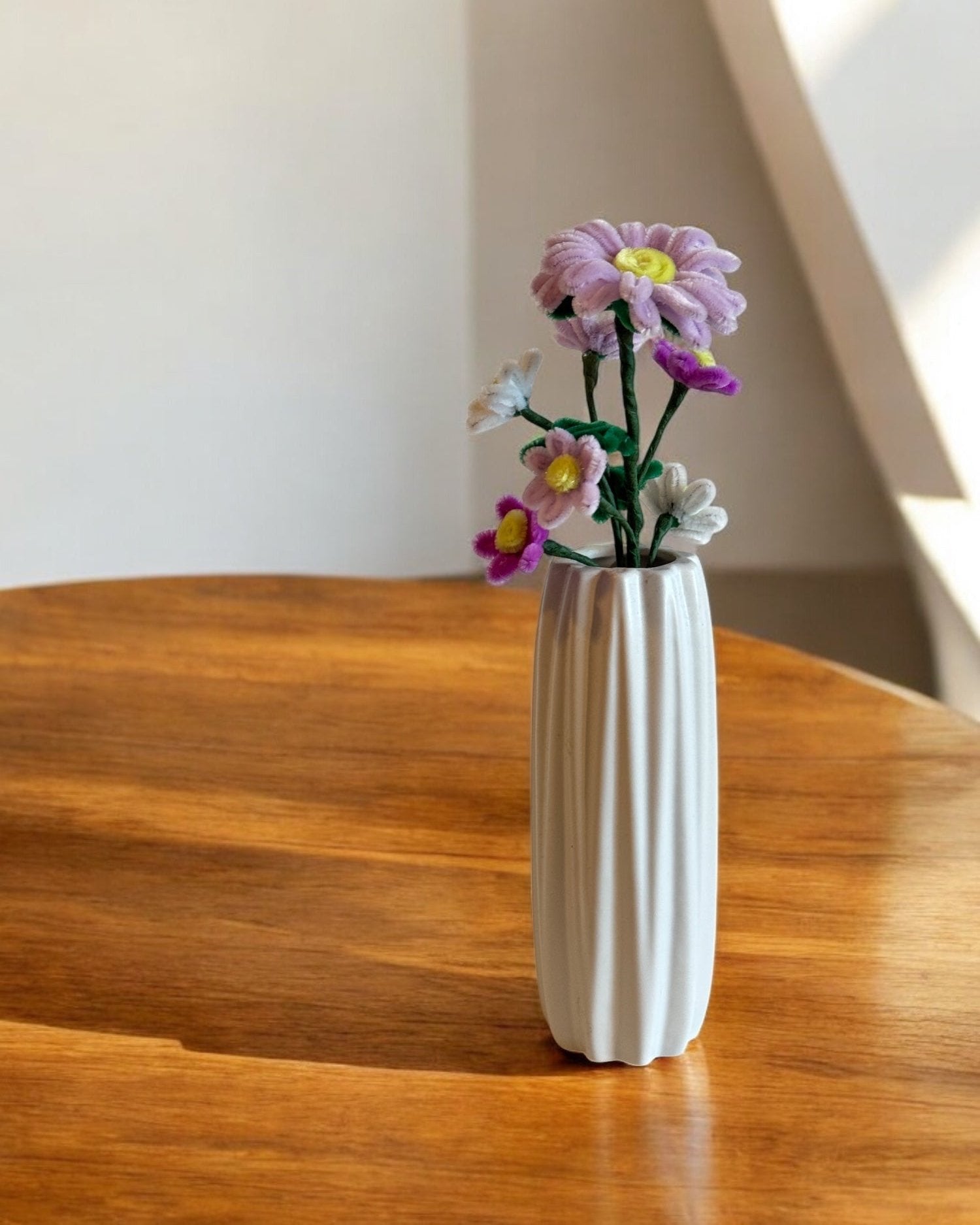 Šopek iz kosmatih žičk, na leseni mizi, v beli vazi, dekoracija.