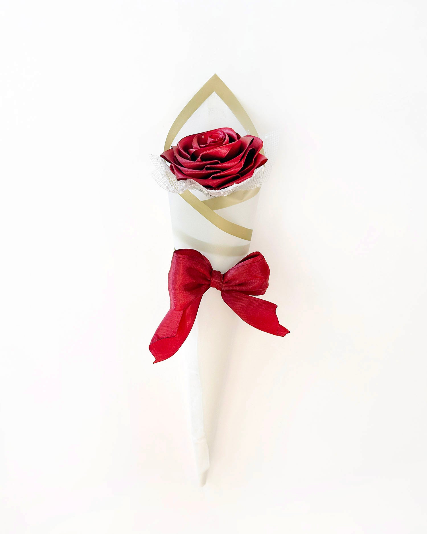 Satenasta vrtnica v bordo rdeči barvi, ovita v bel korejski papir, na beli podlagi

