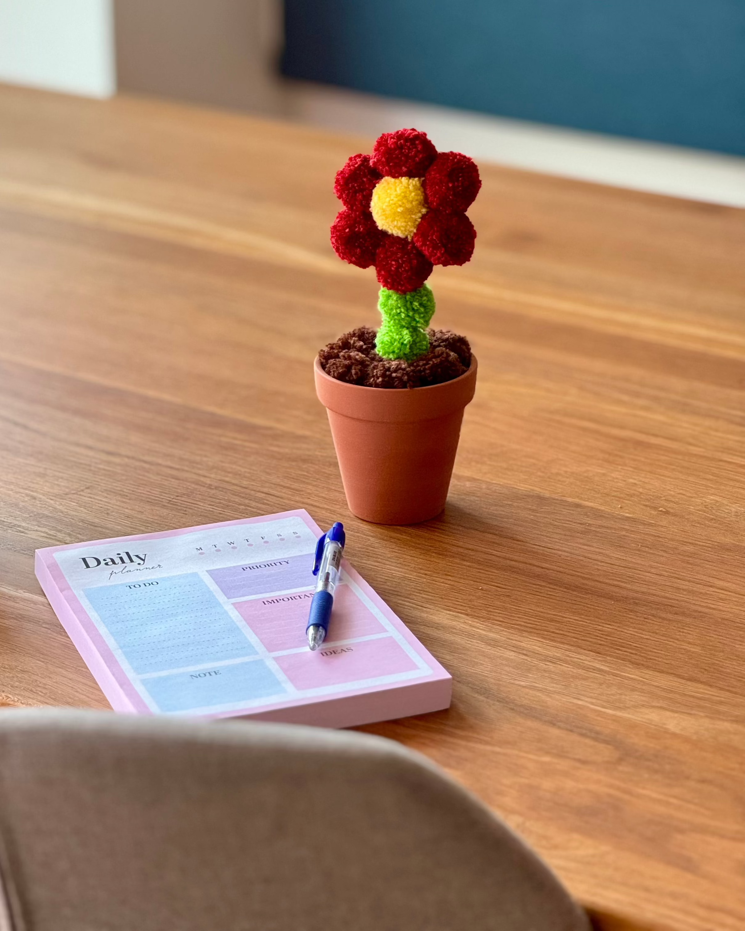 Pom pom roža v glinenem lončku, na leseni mizi, dekoracija v jedilnici, zapisovanje, kava, šalica za kavo